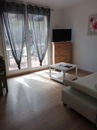 - un salon avec un canapé et une table en face d'une fenêtre dans l'établissement Digne vallon des sources, à Digne-Les-Bains