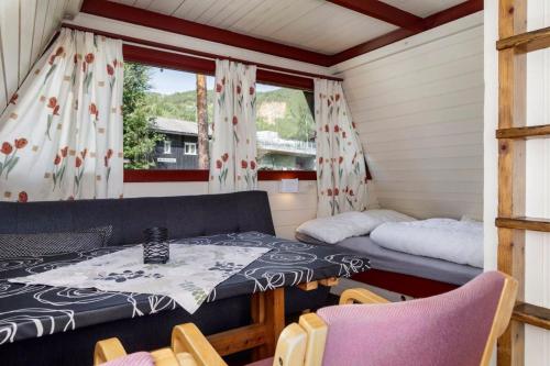 a room with a bed and a table and chairs at Hallingparken in Gol