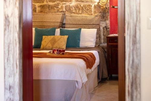 a bedroom with a large bed with colorful pillows at La Casa di Zaira in Alghero