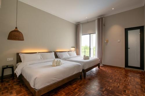a bedroom with two beds and a large window at Kontor Mansion - 3 mins to Teluk Chempedak Beach & Private Pool in Kuantan