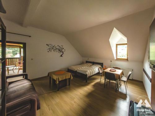 a living room with a bed and a table at Złoty Sen Agroturystyka in Stronie Śląskie