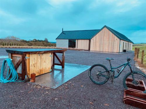 a bike parked next to a table and a building at Rusty Ram Luxury Lodge in Haruru