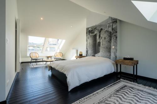 a bedroom with a king sized bed and a large window at La Maison Noire in La Roche-en-Ardenne