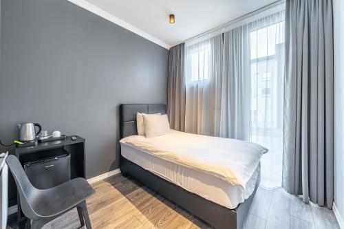 um quarto com uma cama, uma cadeira e uma janela em Hotel Aska em Reykjavík