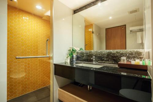 a bathroom with a sink and a mirror at Montana Bangkok Hotel & Residence SHA Extra Plus in Bangkok