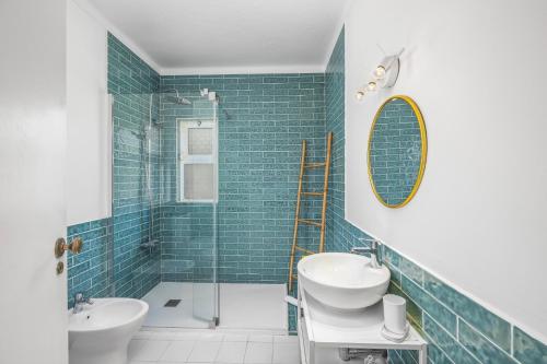 een badkamer met een bad, een wastafel en een spiegel bij Villa Casa Pimenteira by Villa Plus in Lagoa