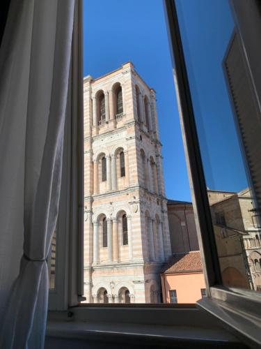 a view of a tall tower from a window at La Suite di Giulia in Ferrara