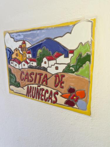 um sinal na parede que lê casita de mincegas em Casa Muñecas em Montejaque