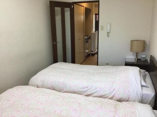 Łóżko lub łóżka w pokoju w obiekcie Business Inn Grandeur Fuchu