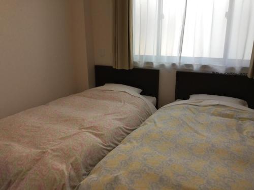 Letto o letti in una camera di Business Inn Grandeur Fuchu