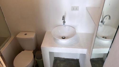 a bathroom with a sink and a toilet at Yay Lodge SIARGAO, private room 2 with AC & hot shower and fast Starlink Wifi in General Luna