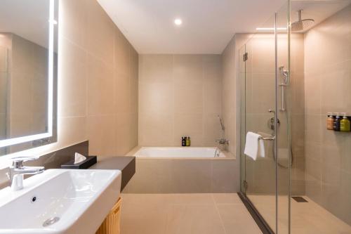 a bathroom with a shower and a sink and a bath tub at Holiday Inn Sepang - Airport in Sepang