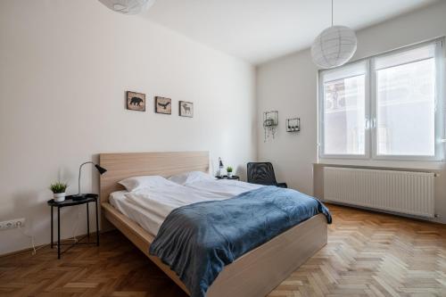 een slaapkamer met een groot bed en een raam bij Liget Apartment in Boedapest