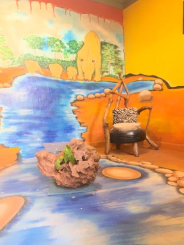 a room with a mural of an elephant and a table at Tortoise park, Ecolodge & Campsite in Lugala
