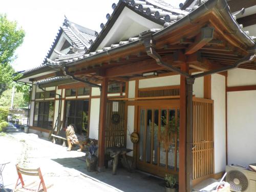 an asian style house with a gate and a bench at COZY Inn Free Shuttle service in Nikko