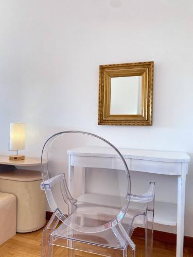 a glass table with a clear chair in a room at Olivrea Design Palazzo in Ivrea