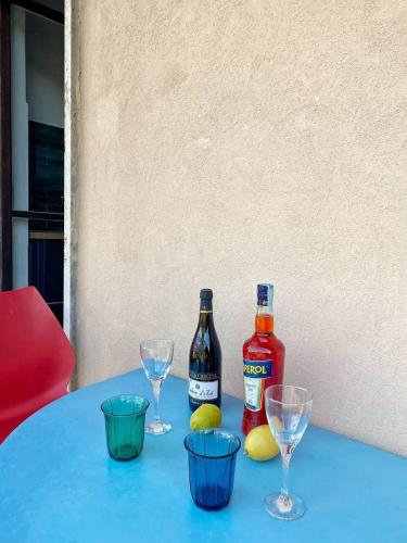 a blue table with two bottles and glasses on it at Olivrea Design Palazzo in Ivrea