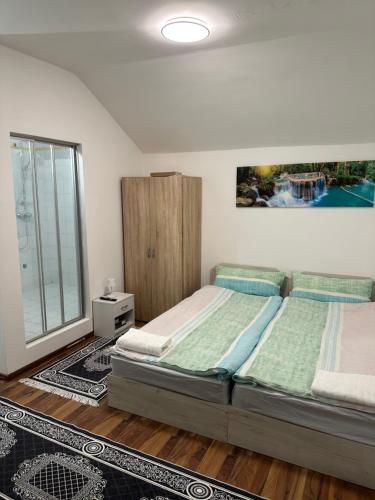 een slaapkamer met 2 bedden en een groot raam bij Privat zimmer ERONN VEİTSCH in Veitsch