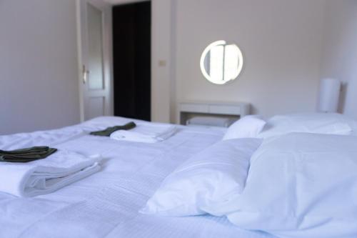 a white bed with white sheets and towels on it at Olivrea Design Palazzo in Ivrea