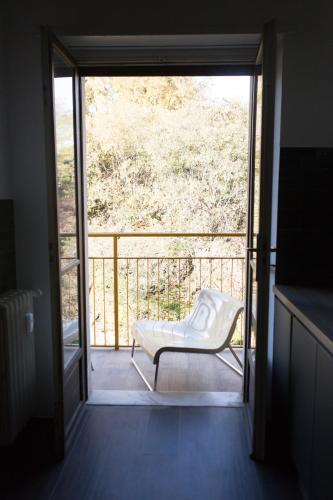 a door to a balcony with a chair on a porch at Olivrea Design Palazzo in Ivrea