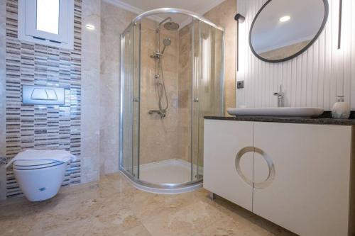 een badkamer met een douche, een toilet en een wastafel bij BEACH FRONT SUPER VİLLA Boss 1 in Bodrum City