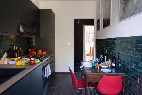 a kitchen with a table and red chairs in it at Olivrea Design Palazzo in Ivrea