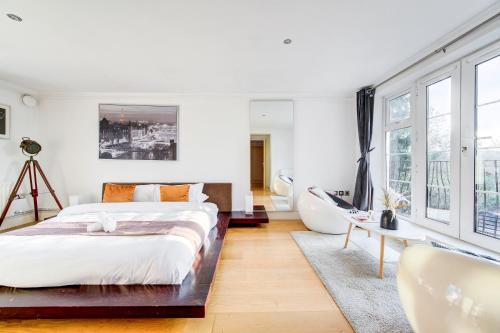 a white bedroom with a large bed and a tub at 3-Bedroom Penthouse, Brentford, Free Parking in Brentford