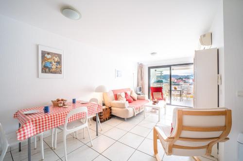 un salon avec une table et un canapé dans l'établissement Le Nautilus - Charmant apt proche de la plage, à Port-Vendres