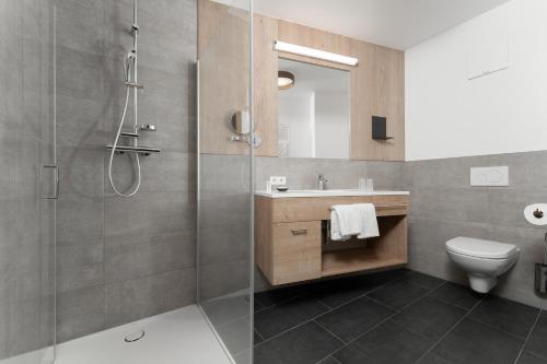 a bathroom with a shower and a toilet and a sink at A Casa Elements in Serfaus