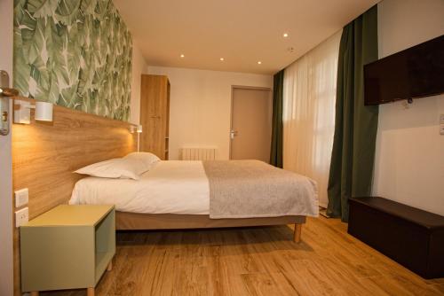 a hotel room with a bed and a television at Hôtel Océan Dinan in Dinan