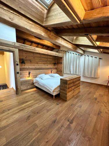 ein Schlafzimmer mit einem Bett und einer Holzdecke in der Unterkunft Chalets ASA 426 m2 in Chamonix-Mont-Blanc