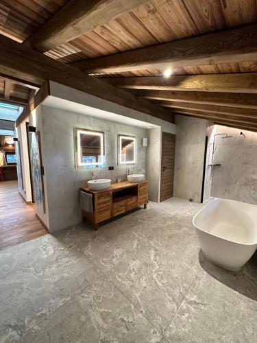 een badkamer met 2 wastafels en een groot bad bij Chalets ASA 426 m2 in Chamonix-Mont-Blanc