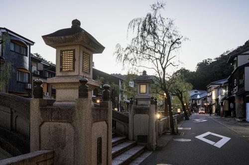 a street with a stone fence with lights on it at Shinzan Kinosaki in Toyooka