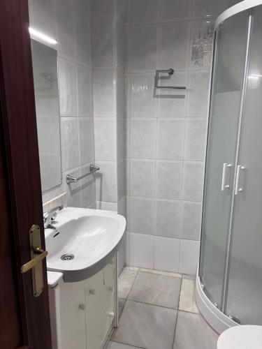 a white bathroom with a shower and a sink at Alojamientos María 2 in Seville