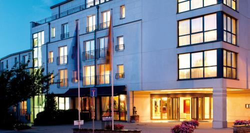 ein großes weißes Gebäude mit vielen Fenstern in der Unterkunft Victor's Residenz-Hotel Erfurt in Erfurt