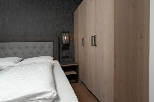 a bedroom with a white bed and a wooden cabinet at A Casa Elements in Serfaus