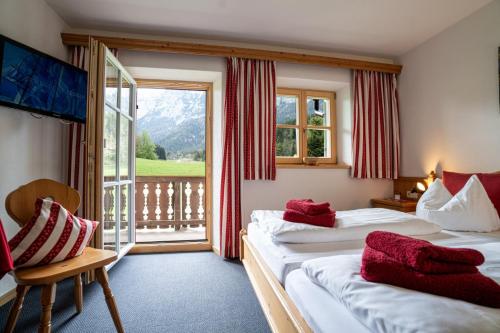 a hotel room with two beds and a balcony at Gästehaus Hinterponholz in Ramsau