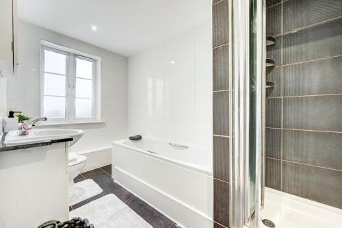 a bathroom with a shower and a toilet and a sink at 3-Bedroom Penthouse, Brentford, Free Parking in Brentford