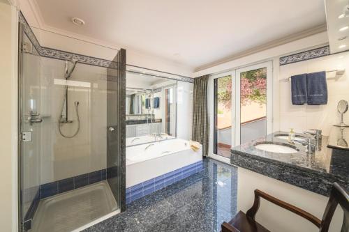 a bathroom with a tub and a sink and a shower at Villa Rostrum by Villa Plus in Funchal