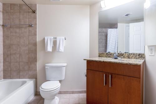 a bathroom with a toilet and a tub and a sink at Foggy Bottom 1BR w Gym DM Roof nr Georgetown WDC-174 in Washington, D.C.