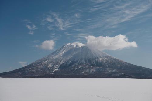 a snow covered mountain in the distance with a blue at Andaru Collection Niseko in Kutchan