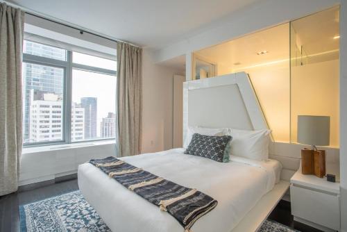um quarto de hotel com uma cama com uma grande janela em Financial District 1br w WD gym elevator NYC-1370 em Nova York