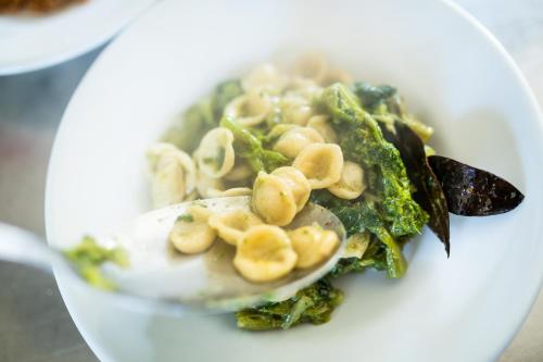 a bowl of food with pasta and greens on a plate at Masseria Il Vignale in Ostuni