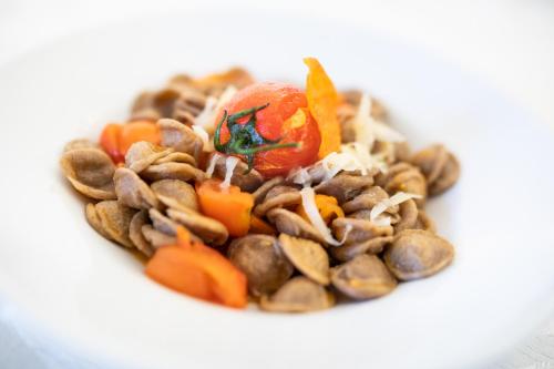 a white bowl of food with pasta and vegetables at Masseria Il Vignale in Ostuni