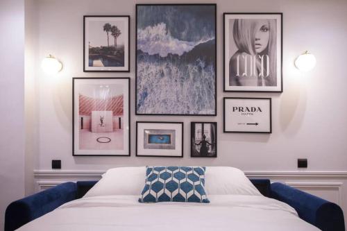 Cette chambre comprend un lit avec des photos sur le mur. dans l'établissement Chic & Fully-Equipped Apartment in Le Marais, à Paris