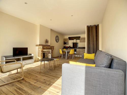 a living room with a couch and a television at [L'ABBAT-JOUR] Le Béryl • Plein Sud • Thermes in Bagnères-de-Bigorre