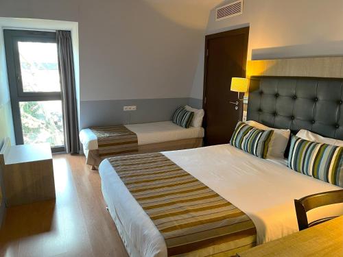 a hotel room with two beds and a window at Kyriad Argenteuil in Argenteuil