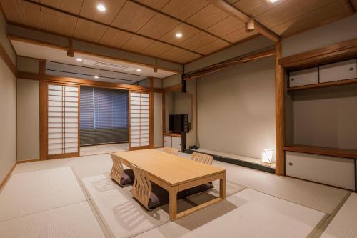 a room with a table and a tv in it at Shinzan Kinosaki in Toyooka