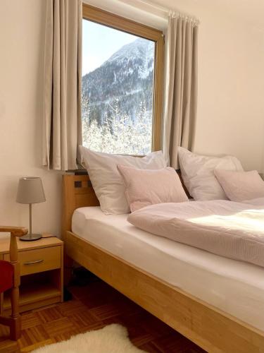 two beds in a room with a large window at Ferienwohnung Waldgarten in Leiten