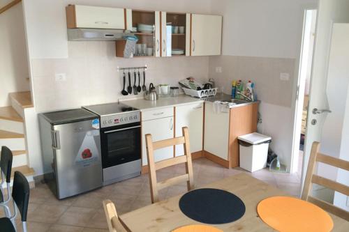 a kitchen with a stainless steel stove and a table at Bovec Garni Apartment 7 in Bovec